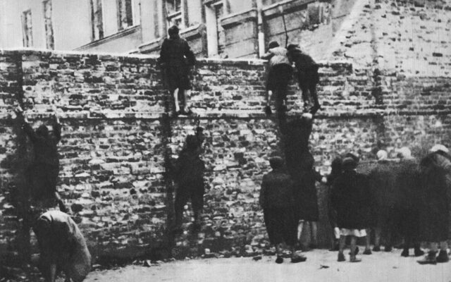 Getto warszawskie. Dzieci przechodzące przez mur getta. Fot. autor nieznany, domena publiczna